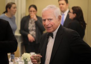 Hon. Paul L. Rudman smiles for the camera at an event. 